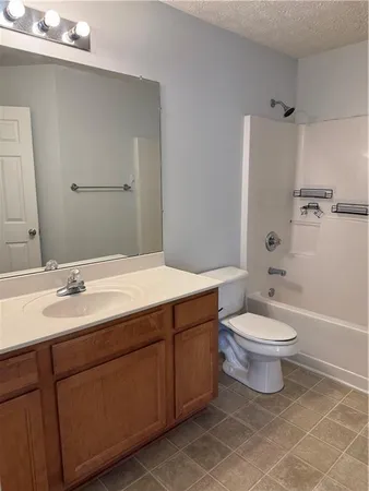 a bathroom with a toilet a sink a mirror a bathtub and shower