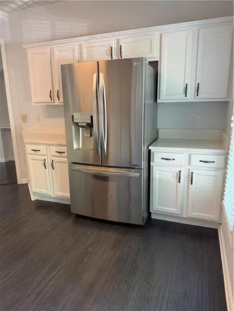 a kitchen with stainless steel appliances white cabinets and wooden floors