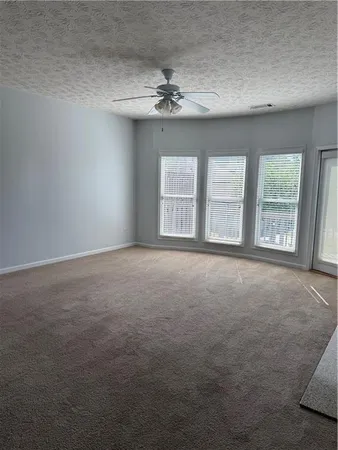 an empty room with windows and chandelier