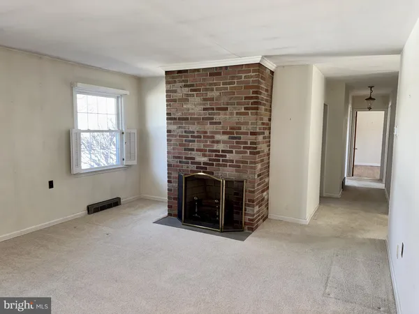 a view of an empty room with a fireplace and a window
