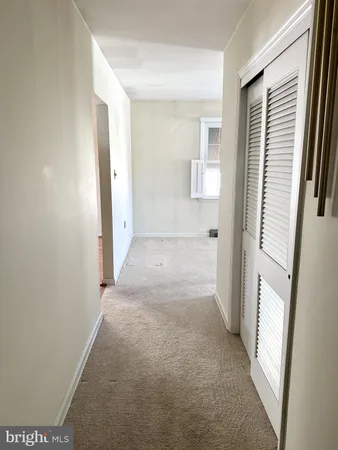 a view of a hallway with wooden floor and windows