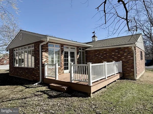 a view of a house with a wooden deck and a yard