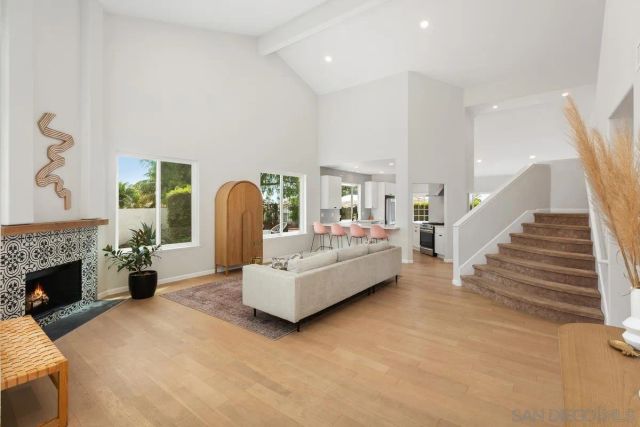a living room with furniture a fireplace and a large window