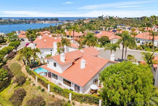 an aerial view of ocean and residential houses with outdoor space