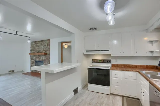 a kitchen with granite countertop white cabinets and white appliances