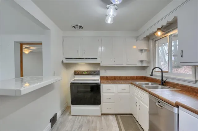 a kitchen with stainless steel appliances granite countertop a sink and a stove