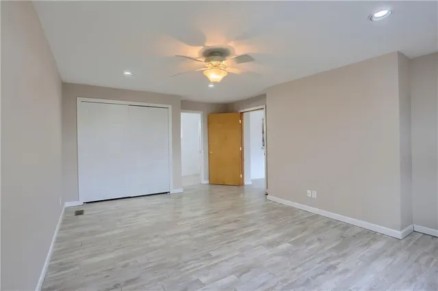 a view of an empty room with window and wooden floor