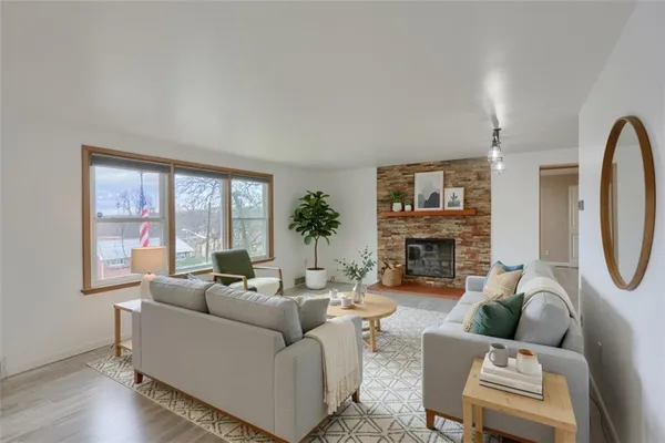 a living room with furniture a fireplace and a large window