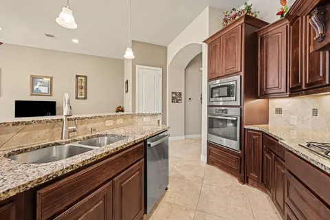 a kitchen with stainless steel appliances granite countertop a sink stove and refrigerator