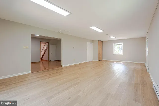 a view of empty room with wooden floor and window