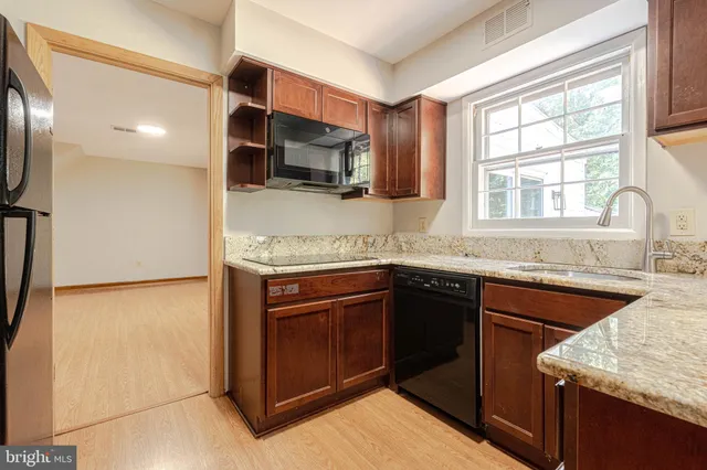 a kitchen with stainless steel appliances granite countertop a sink stove and microwave