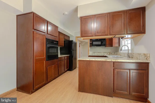 a kitchen with stainless steel appliances granite countertop a refrigerator a stove and a sink