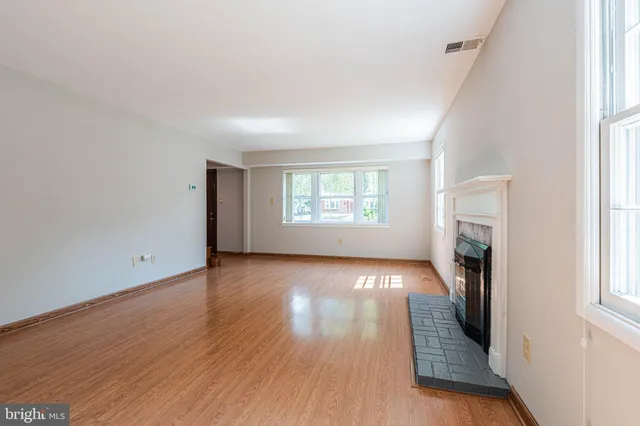 an empty room with wooden floor and a window