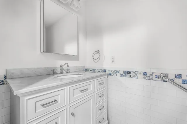 a bathroom with a granite countertop sink and a mirror