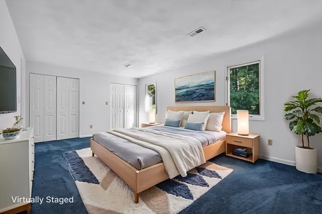 a bedroom with a large bed and a potted plant
