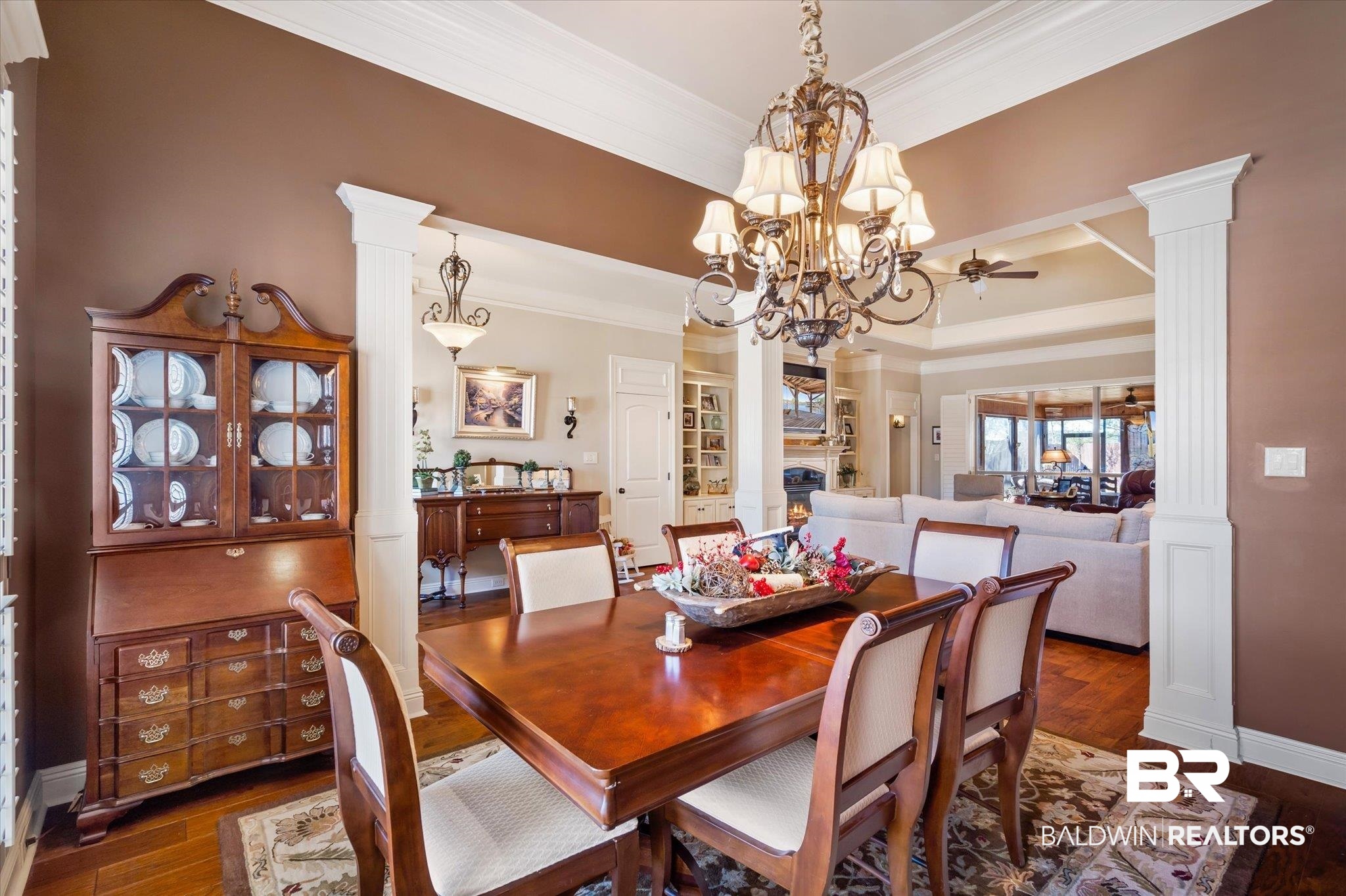 5683 Spring Landing Drive Theodore, AL 36582 - Photo 5 of 49 Dining room with ceiling fan with notable chandelier, ornamental molding, dark hardwood / wood-style flooring, and ornate columns