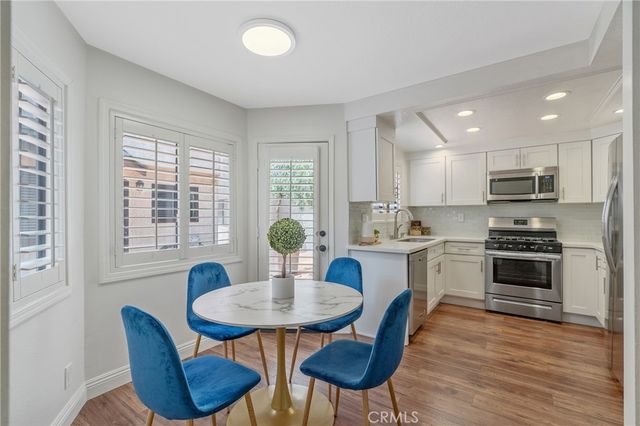 a kitchen with stainless steel appliances kitchen island granite countertop a kitchen island a stove a table and chairs