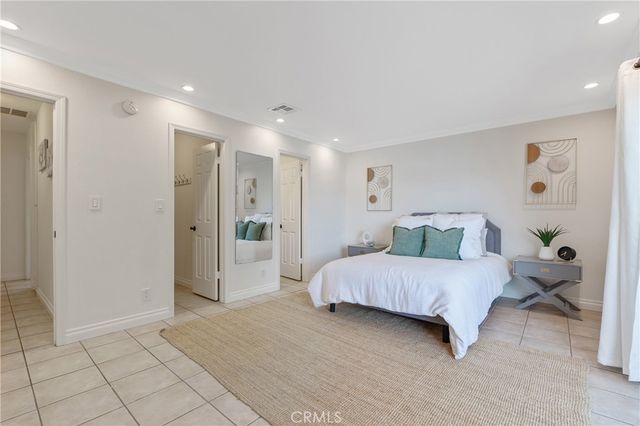 a spacious bedroom with a bed and a view of bathroom