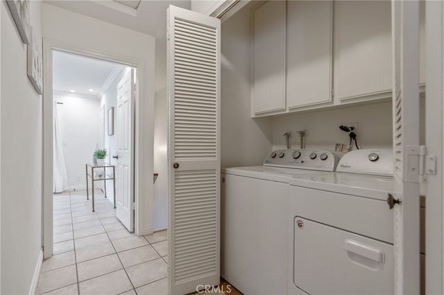 a utility room with cabinets washer and dryer