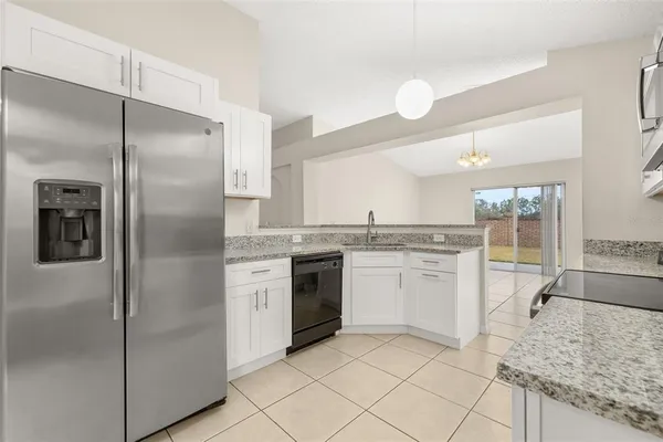 a kitchen with a refrigerator sink and cabinets