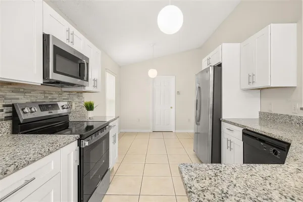 a kitchen with stainless steel appliances granite countertop a stove a sink and a microwave