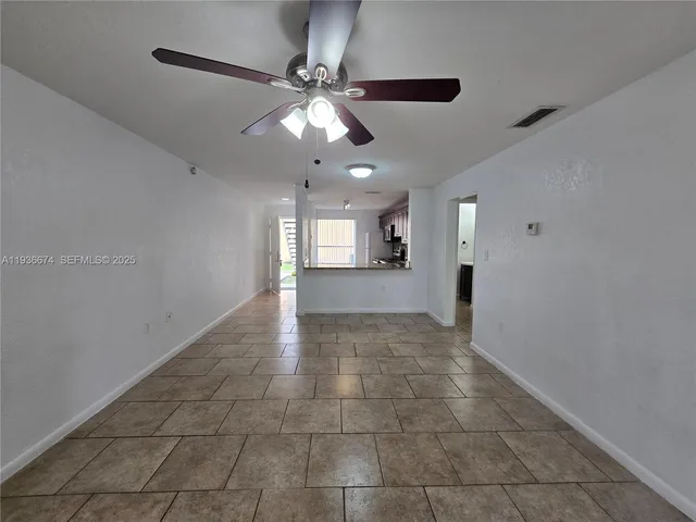 a view of a livingroom with a ceiling fan and kitchen view
