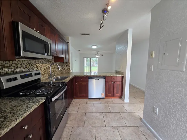 a kitchen with stainless steel appliances granite countertop a stove top oven microwave and cabinets