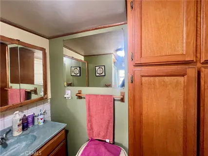 a bathroom with a sink mirror toilet and window