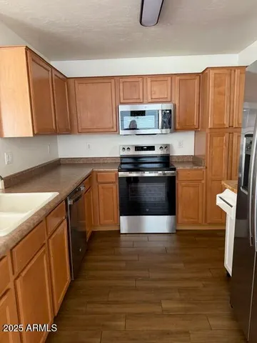 a kitchen with stainless steel appliances granite countertop a stove a sink and a refrigerator