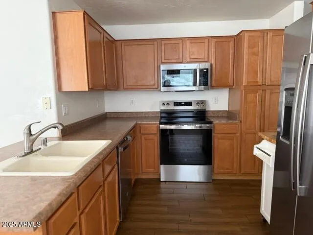 a kitchen with stainless steel appliances a stove a sink and a refrigerator