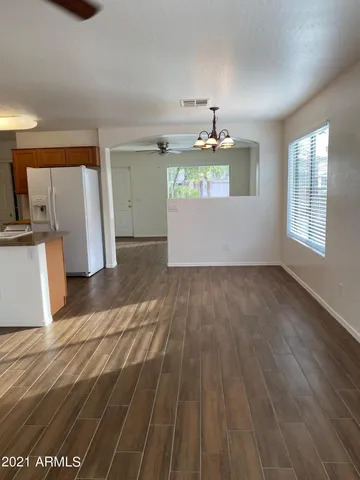 a view of a kitchen with wooden floor and electronic appliances
