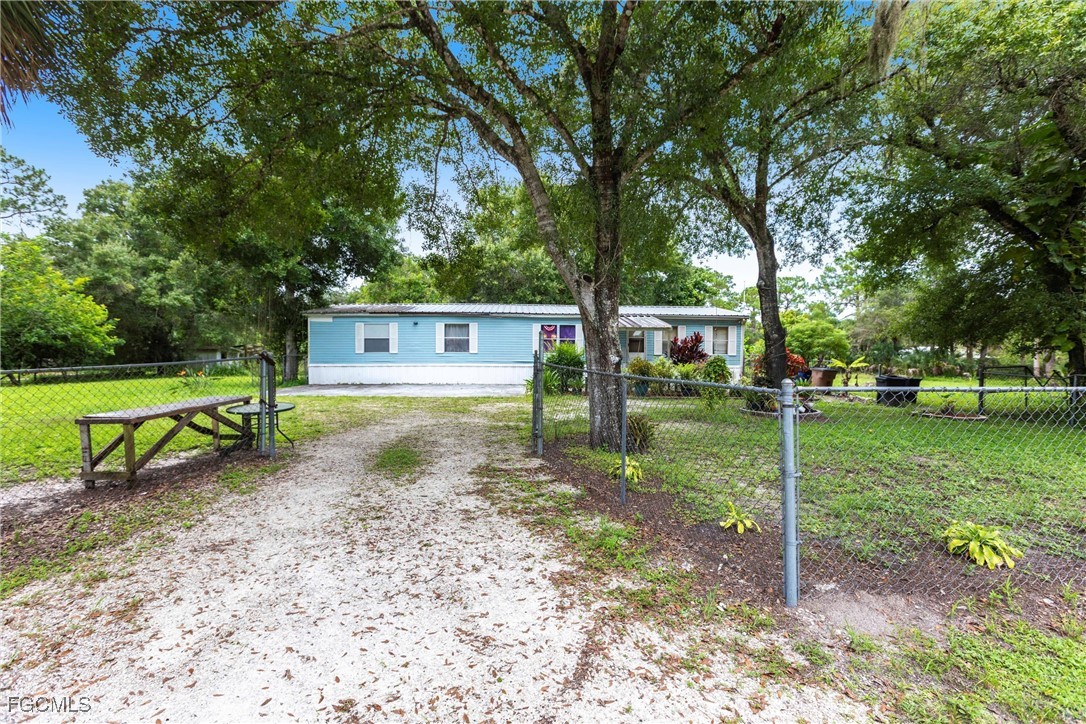 3180 Packinghouse Road Alva, FL 33920 - Photo 1 of 9 a view of a house with a yard and a large tree