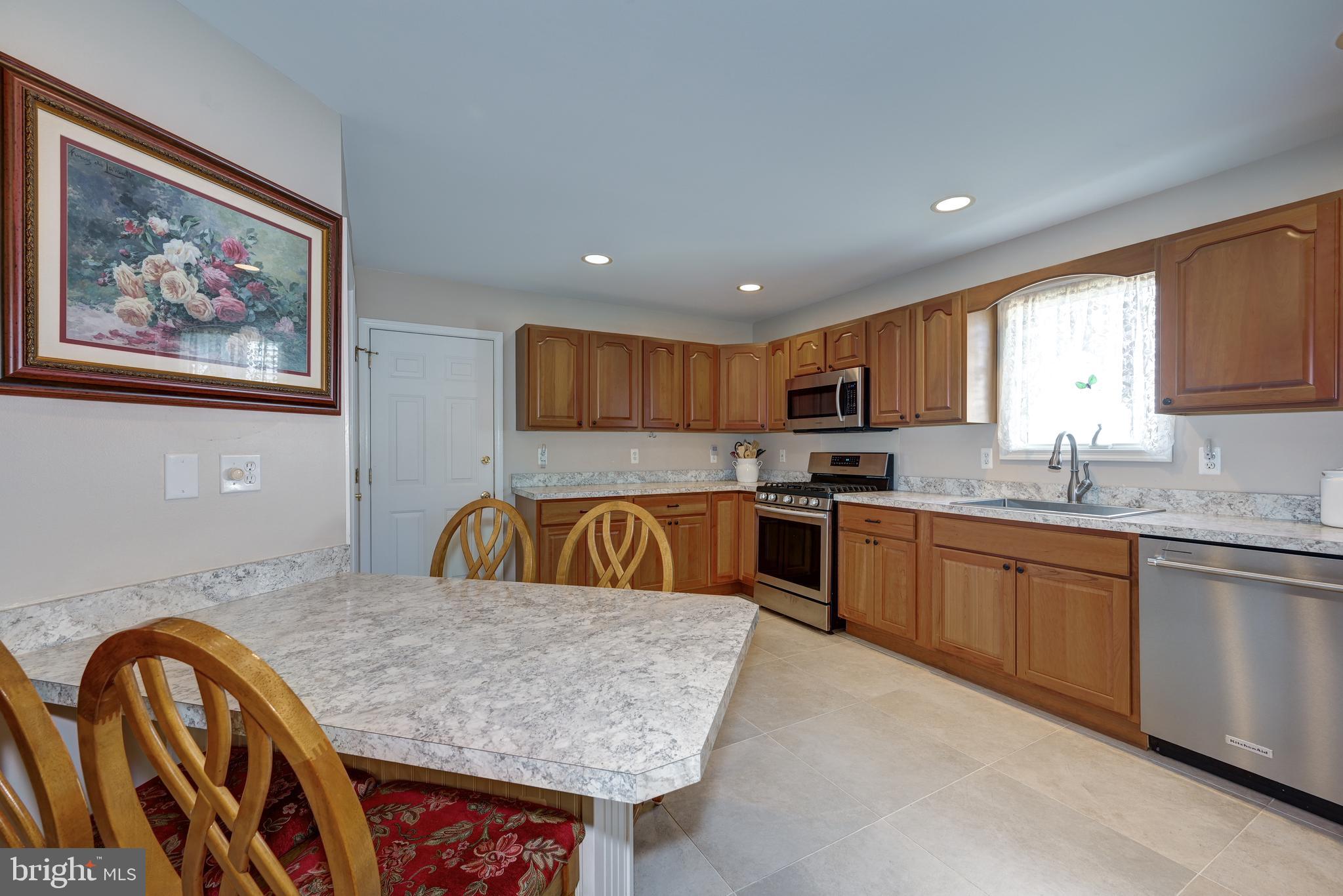 137 Skipper Road Manahawkin, NJ 08050 - Photo 12 of 33 a kitchen with stainless steel appliances granite countertop a kitchen island a stove a sink a window and a dining table