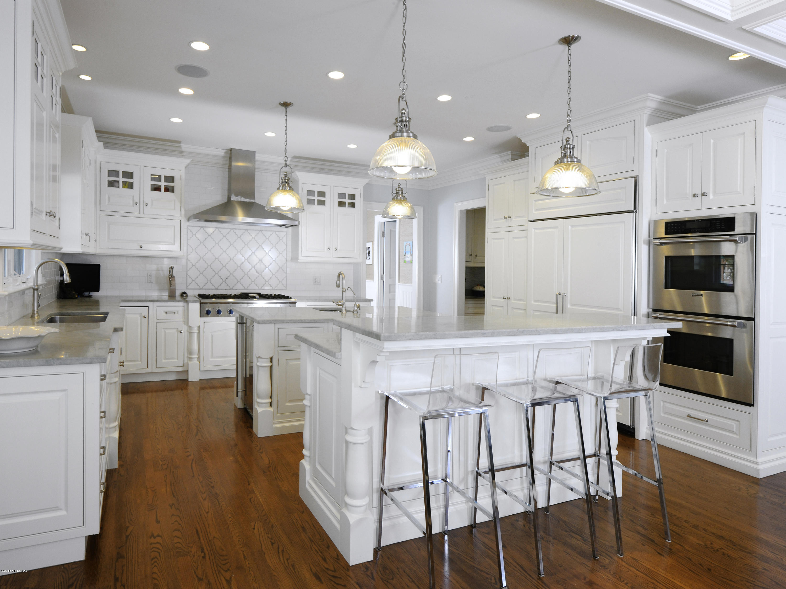 58 Brookridge Drive Greenwich, CT 06830 - Photo 7 of 18 a kitchen with stainless steel appliances kitchen island granite countertop a stove a sink a refrigerator and a dining table with wooden floor