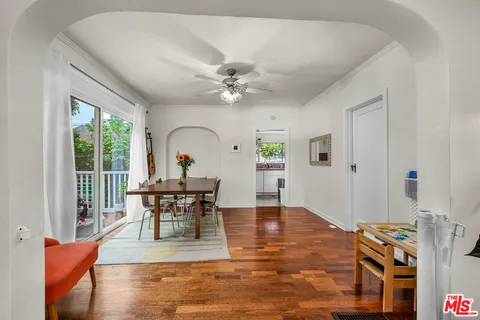 a living room with furniture a dining table and a floor to ceiling window