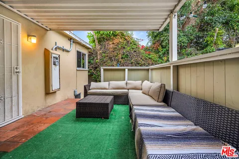 a view of a patio with couches chairs and backyard