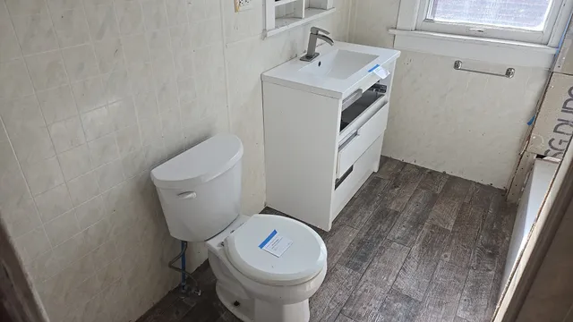a white toilet sitting next to a sink and vanity