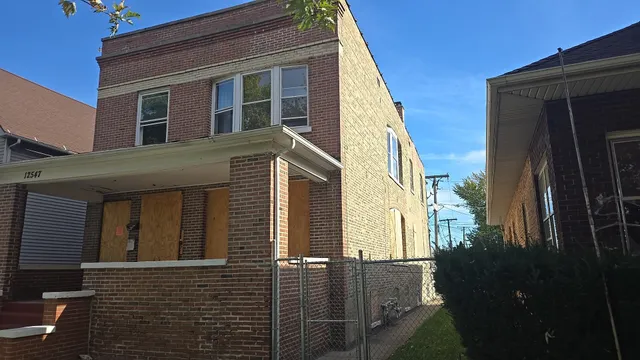 a view of a house with a car park side of road