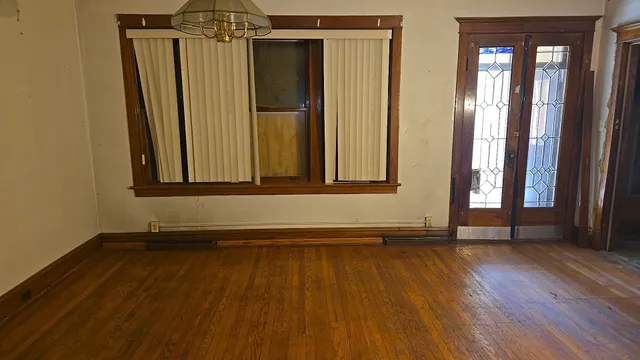 a view of a room with wooden floor and a window