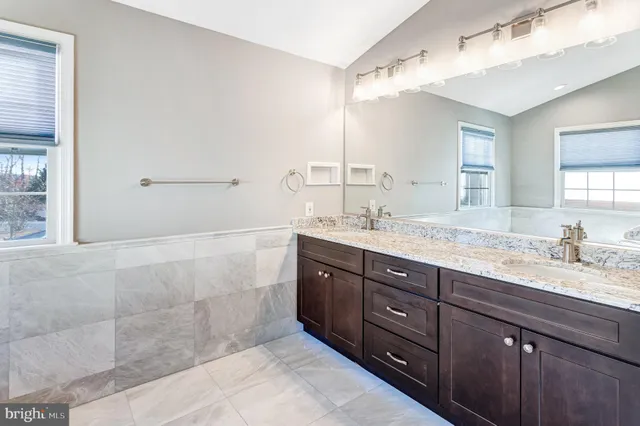 a bathroom with a granite countertop sink mirror and double
