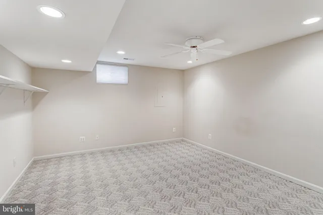 an empty room with a ceiling fan and window