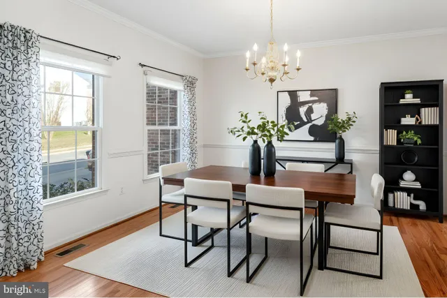 a dining room with furniture potted plants and wooden floor