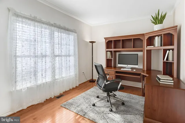a view of a workspace with furniture and a window