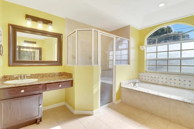 a bathroom with a tub sink and mirror