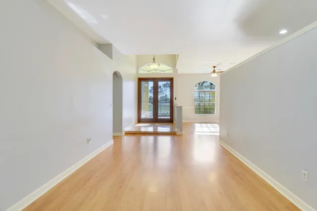 a view of an empty room with wooden floor and a window