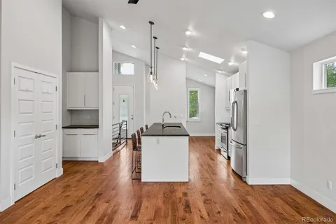 a kitchen with stainless steel appliances a refrigerator sink and white cabinets