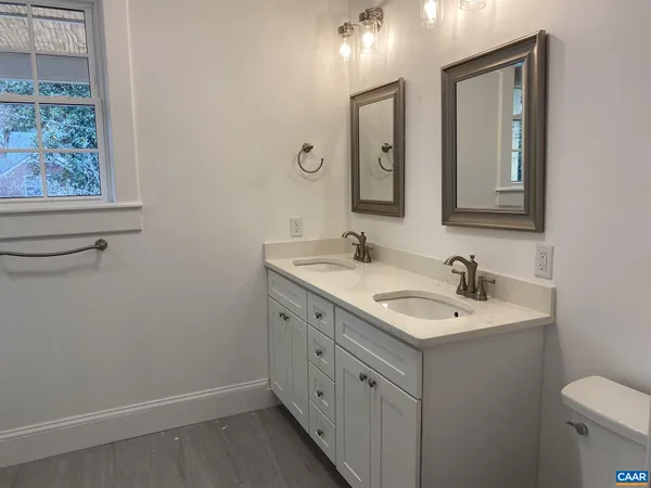 a bathroom with 2 sink and a mirror