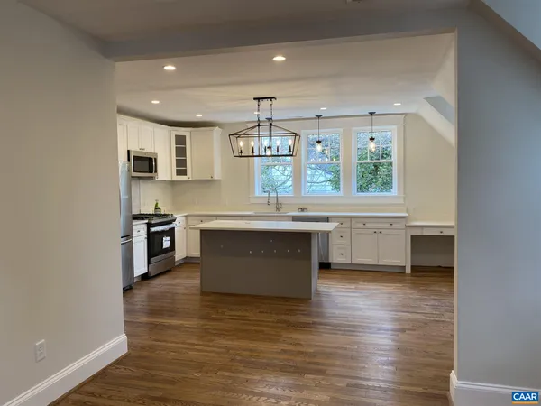 a large kitchen with stainless steel appliances a sink and cabinets