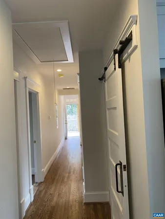 a view of a hallway with wooden floor and staircase