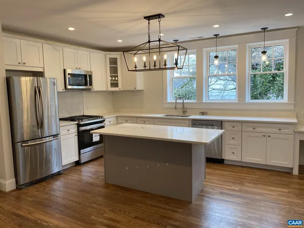 a kitchen with stainless steel appliances granite countertop a refrigerator a sink dishwasher a stove and a refrigerator